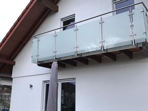 Balkongeländer mit Glasfüllung an einem Wohnhaus