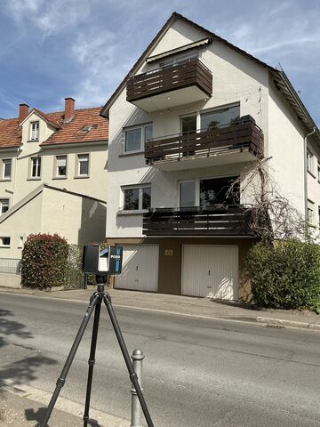 Laserscanner vor einem Wohnhaus während der 3D-Vermessung des Bestands
