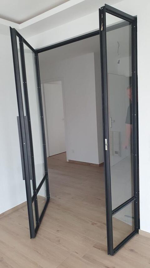 Zweiflügelige Stahl-Glas-Lofttür, geöffnet, in einem hellen Neubau