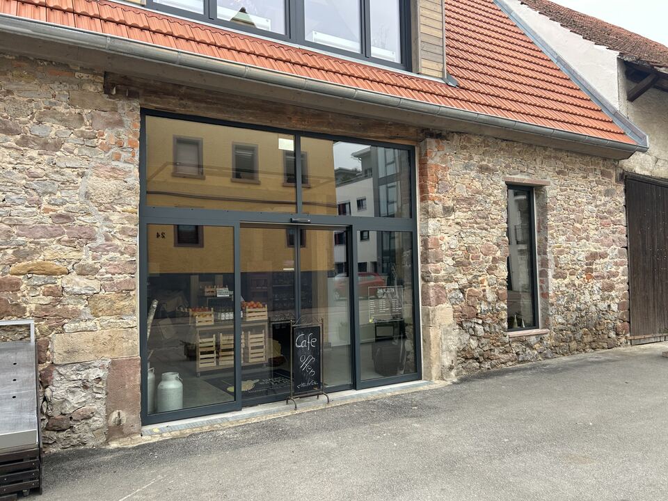 Stahl-Glas-Schaufensteranlage in einer Natursteinfassade