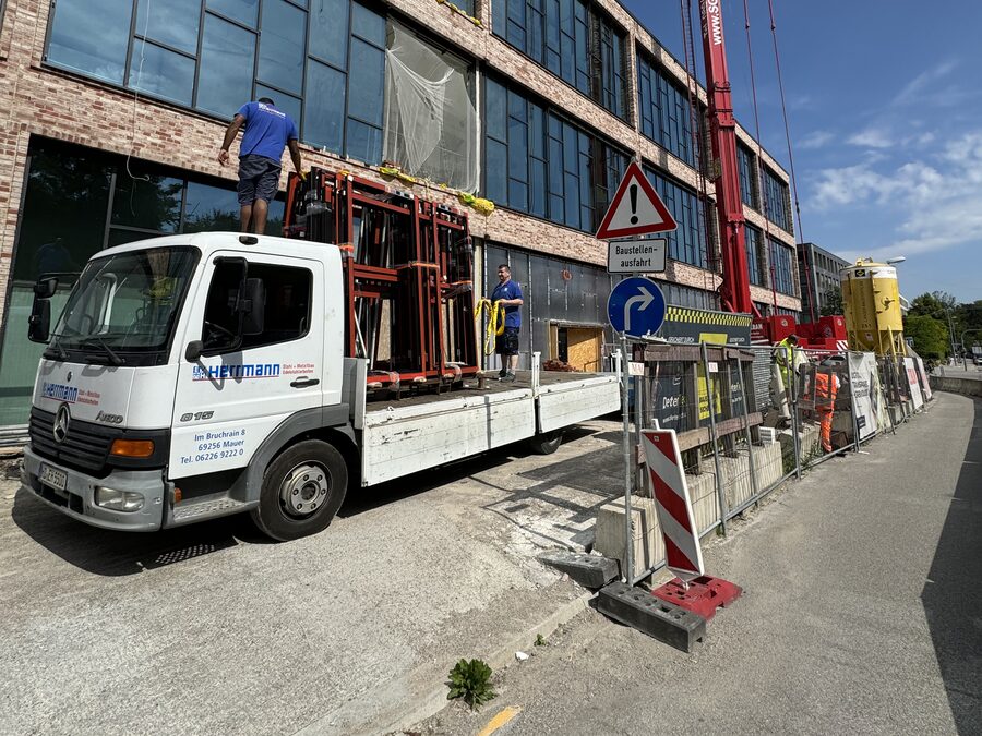 Zwei Kollegen bei der Anlieferung von Fassadenelementen an der Baustelle